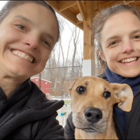 twin sisters volunteering with an adoptable dog