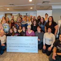 a group of volunteers with a large check
