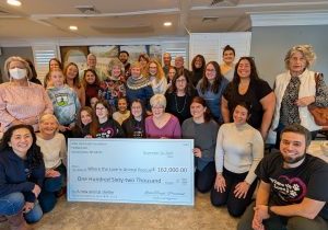 a group of volunteers with a large check